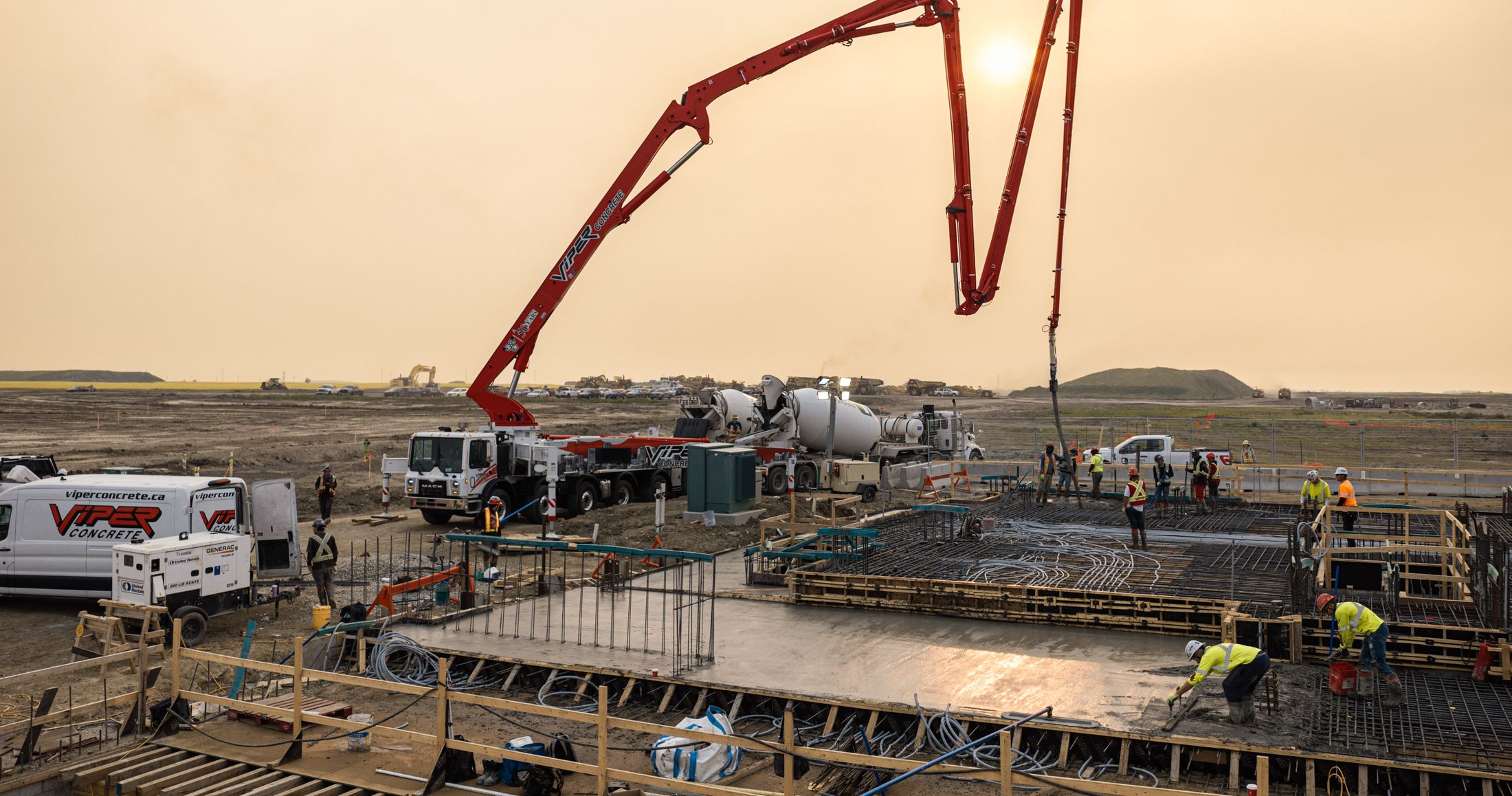 Aerial view of a concrete pour on a Calgary construction site with boom pumps and crews