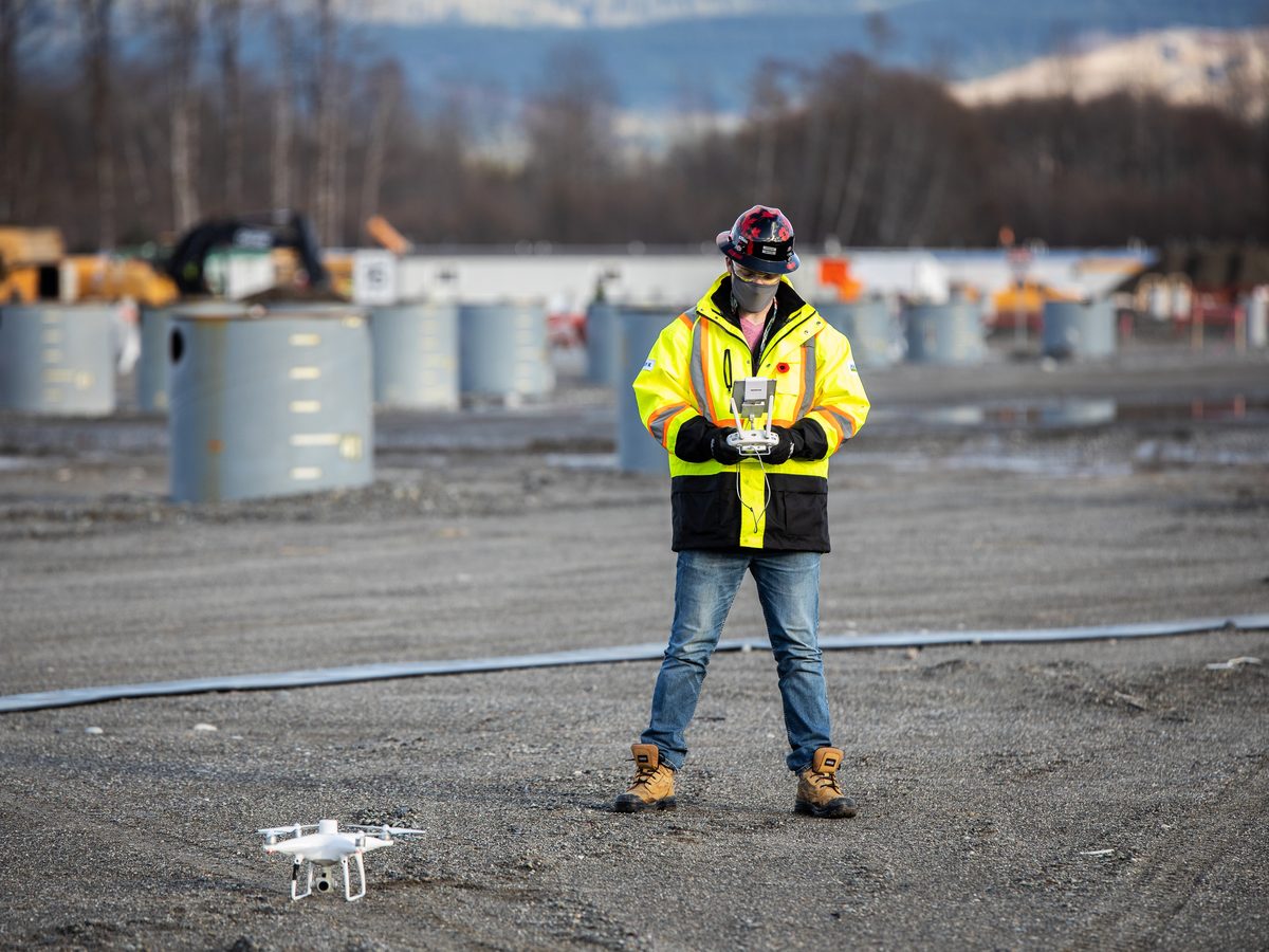 Drone pilot in full PPE operating on an industrial site