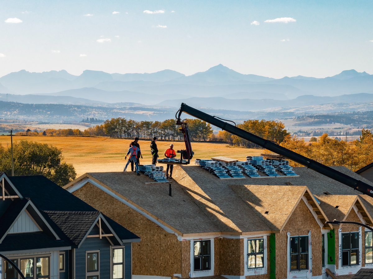 Aerial view of roof framing on new homes with the Rocky Mountains behind