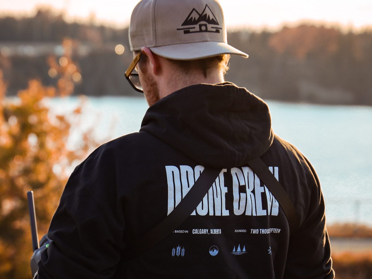 Peak FPV drone pilot on location in Alberta wearing a Drone Crew jacket